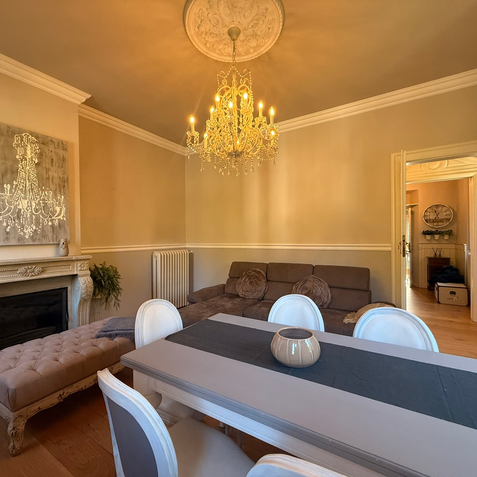 salotto con tavolo da pranzo, divano e caminetto decorativo