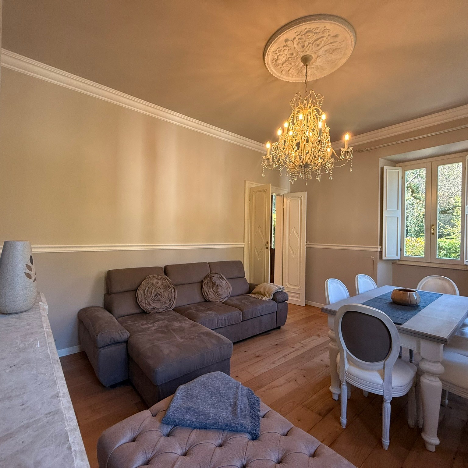 salotto con tavolo da pranzo, divano e caminetto decorativo